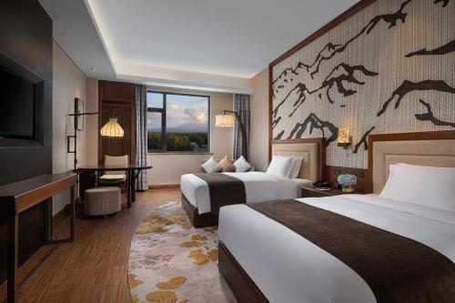 安图县长白山温泉皇冠假日度假酒店的酒店客房设有两张床和一台平面电视。