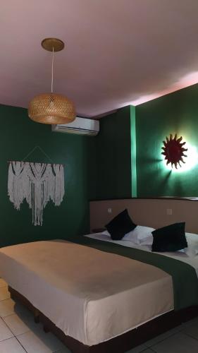 古邦哈斯恩达酒店的一间卧室配有一张带绿色墙壁的床