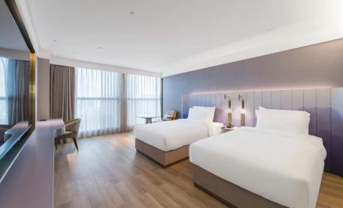广州广州白云机场漫心酒店的酒店客房配有两张床和一张书桌