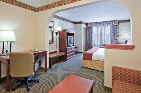 佛瑞斯特森林智选假日套房酒店的酒店客房设有一间带一张床和一张书桌的卧室