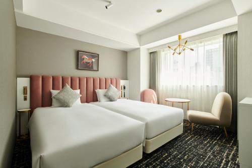 札幌札幌克罗斯酒店的酒店客房,配有两张床和椅子