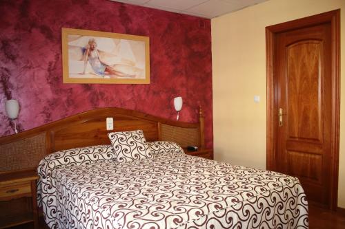 阿尔沃洛特拉科瓦酒店的卧室配有一张床,墙上挂有绘画作品
