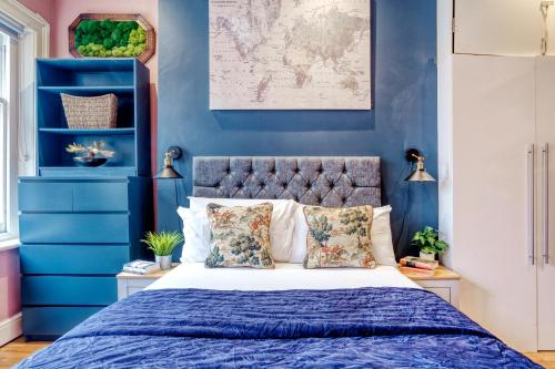 伦敦Sunny Corner Apartment in Center of London的一间卧室拥有蓝色的墙壁,配有一张带枕头的床。