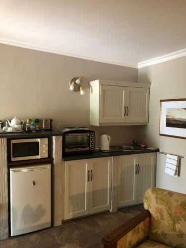 蒙塔古New Song的厨房配有白色橱柜和微波炉
