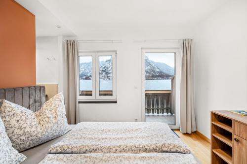 哈尔施塔特Hallstatt Lakeside Top 4 - Zimmer mit Balkon的一间卧室设有一张床和两个窗户。