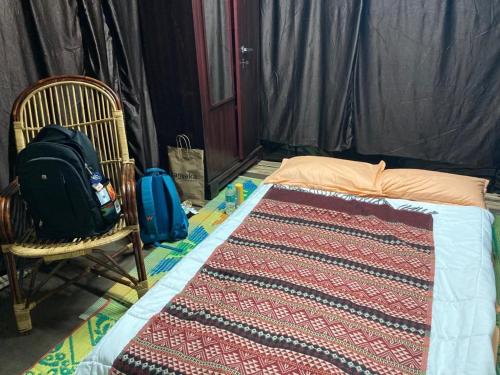 苏丹巴特利Lotus Jewel Forest Camping的一间卧室配有床、背包和椅子