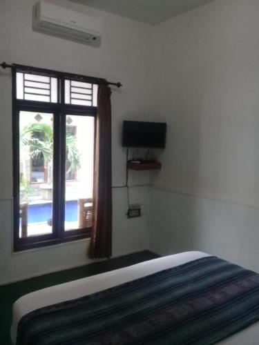 吉利特拉旺安Wahyu Gili 1的一间卧室设有一张床和一个窗口