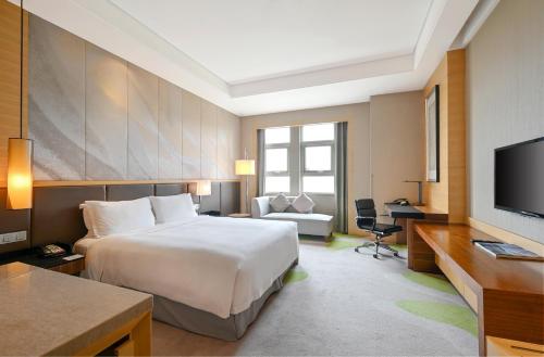 青岛青岛世园假日酒店的酒店客房设有一张大床和一台电视。