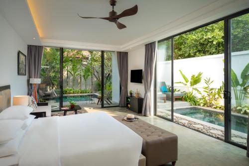 暹粒Eightfold Urban Resort的卧室设有一张白色大床和一个游泳池