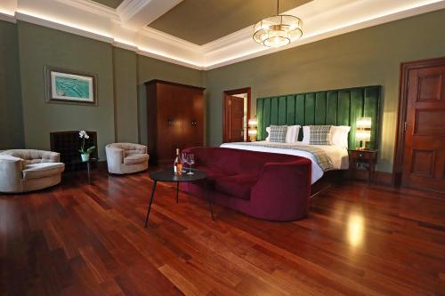 斯旺西摩根斯酒店的一间卧室配有一张床、一张沙发和一张桌子