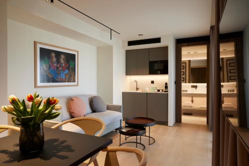 雅典Dusit Suites Athens的客厅配有沙发和桌子