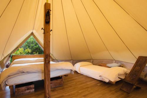 圣维托ecoVita agri-glamping的帆布帐篷内的两张床,配有窗户