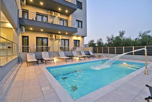 乐托卡亚MAK Apartments的一座带椅子的游泳池和一座位于大楼前的喷泉