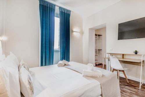 罗马梵蒂冈城旅馆的白色卧室配有一张带蓝色窗帘的大床