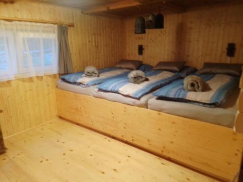 KaltenbergHütte Waldesruh的木制客房内的一间卧室配有两张床