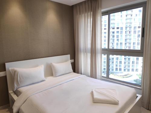 孟买Maxxvalue Apartment Hiranandani Powai的卧室配有一张大白色床和窗户