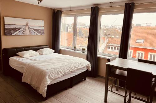 奥斯坦德O-Mer Oostende的卧室配有一张床、一张书桌和窗户。
