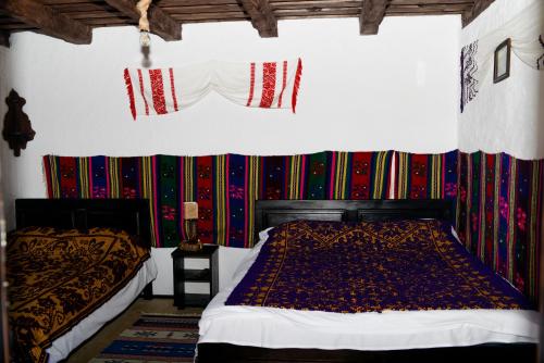 Albeștii de MuscelSatu Muscelean的卧室设有两张床,卧室拥有色彩缤纷的墙壁