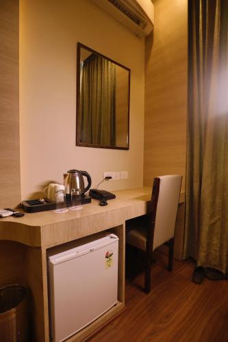 古尔冈GOA COUNTRY CLUB的客房设有带椅子和镜子的书桌