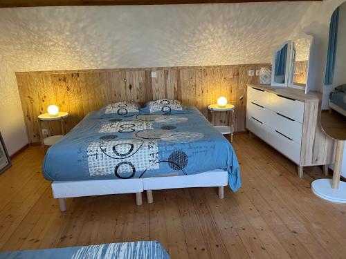 GennevilleLa Charreterie au pays de Honfleur的一间卧室配有一张带蓝色棉被的床