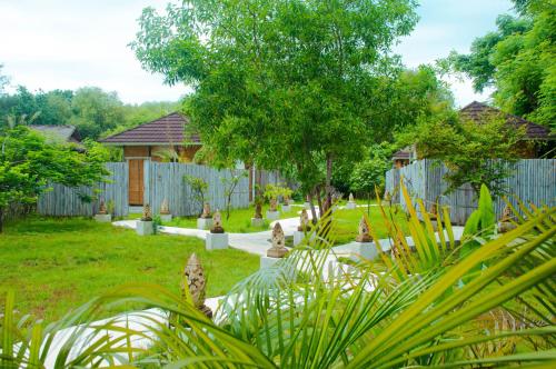 吉利美诺Villa Samalas Resort and Restaurant的后院设有围栏,院子有植物