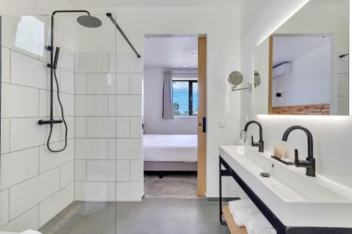 克拉伦代克Belnem House Bonaire的带淋浴、盥洗盆和镜子的浴室