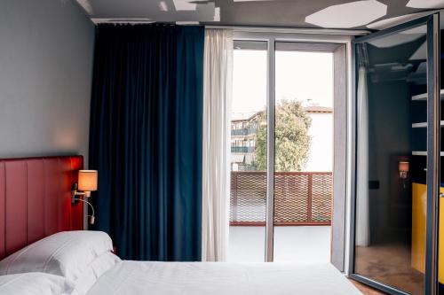 佩斯基耶拉德加达K MODERN HOTEL的一间卧室设有一张床和一个滑动玻璃门