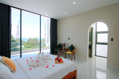头顿Sea Villa Bãi Dâu View Biển - Đi Bộ Ra Biển的卧室配有白色的床铺,上面有红色的鲜花