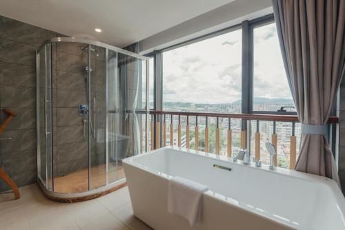 梅州梅州白天鹅迎宾馆的带浴缸的浴室和阳台