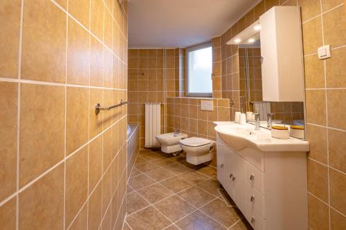 克拉尼斯卡戈拉Alpski škrat, Kranjska Gora的一间带两个盥洗盆、卫生间和窗户的浴室