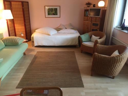 杜塞尔多夫乌特巴赫客用公寓的一间卧室配有一张床、两把椅子和一张沙发