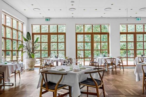 锡尔克堡Gl Skovridergaard的用餐室设有桌椅和窗户。