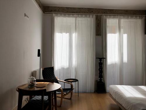 波尔图Belomonte 20 Apartments Porto World Heritage的卧室配有1张床、1张桌子和1把椅子