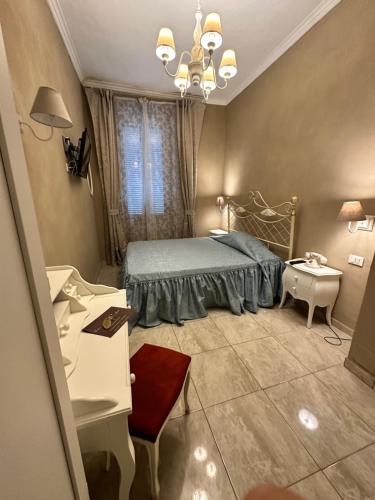 米兰Boutique Hotel Calais Milano的一间卧室配有一张床、一张桌子和一个窗户。