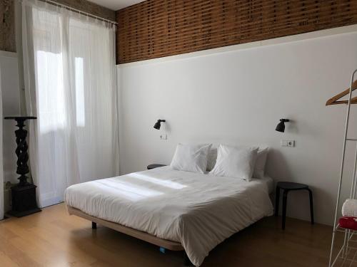 波尔图Belomonte 20 Apartments Porto World Heritage的一间卧室配有一张带白色床单的床和一扇窗户。