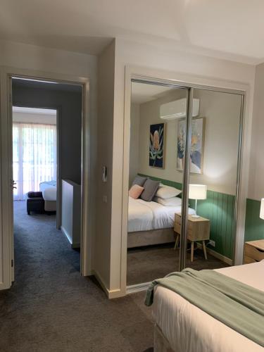 谢珀顿Shepparton Lakeside Serviced Apartment的酒店客房,配有床和镜子