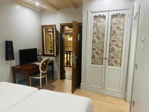 塞维利亚圣安娜圣器珍贵酒店的卧室配有床、书桌和门