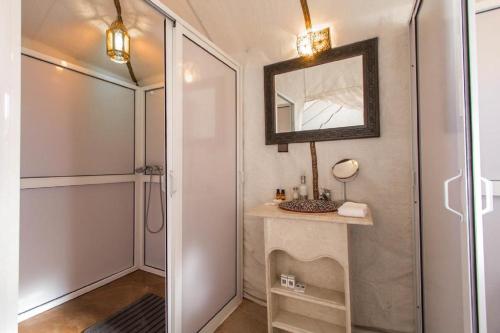 梅尔祖卡Erg chebbi Dunes Desert Camp的一间带镜子、水槽和淋浴的浴室