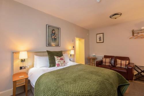 皮克林The Black Swan Inn的一间卧室配有一张床和两把椅子