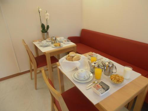 波尔图圣马利诺酒店的一张桌子,上面有食物和饮料,一张桌子和椅子,上面有桌子