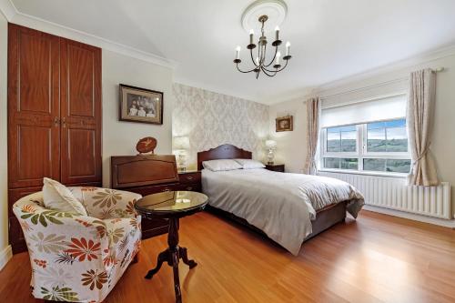 CottianGormley Residence的一间卧室配有一张床、一把椅子和一个吊灯。