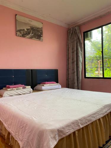古打毛律Muna’s Homestay的一间卧室设有两张床和窗户。