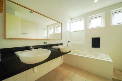 乔治市Nautilus Bay Home Inn的一间带两个盥洗盆和大镜子的浴室