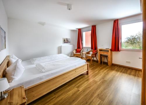欣特察尔滕Hotel Lafette的一间卧室配有大床和红色窗帘