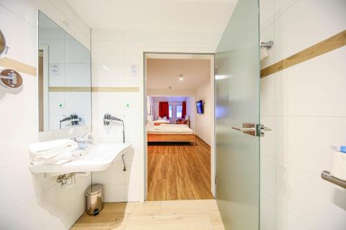 欣特察尔滕Hotel Lafette的一间带水槽和淋浴的浴室
