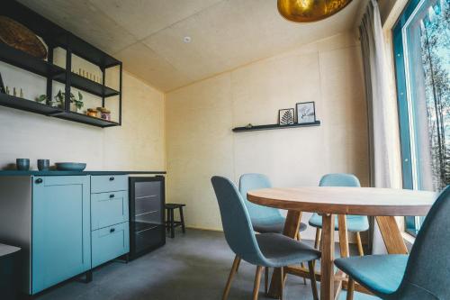 RomppalaVenejoen Piilo - Naava的一间带桌子和蓝色椅子的用餐室