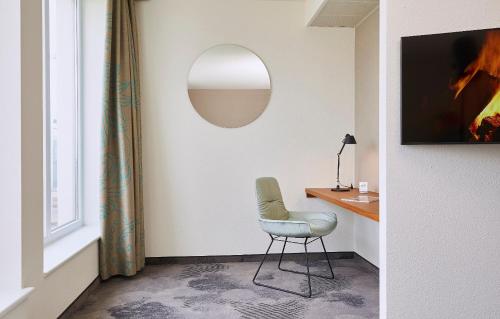 埃森埃森1号汽车旅店的一张椅子,放在带桌子和镜子的房间