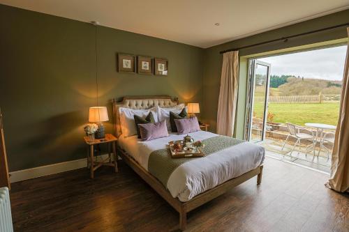 Upper ArleyThe Grange的一间卧室设有一张床和一个滑动玻璃门