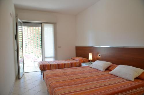 比比翁Residenza Le Acacie的酒店客房设有两张床和一个阳台。