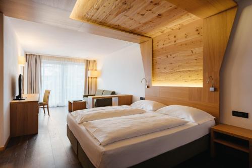 巴迪亚米罗迪亚德尔博斯科酒店的一间卧室设有一张带木制天花板的大床